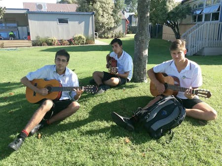 students playing guitar on school campus